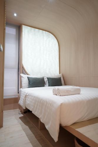 ein großes Bett in einem Zimmer mit Fenster in der Unterkunft W 21 Hotel Bangkok in Bangkok