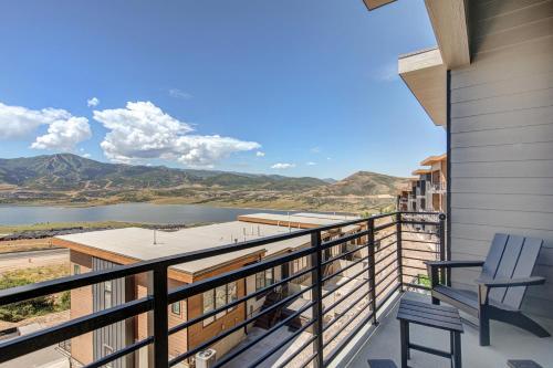 a balcony with two chairs and a view of a lake at On Top of the Mountains - Unit A in Keetley