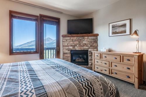 sypialnia z łóżkiem, kominkiem i telewizorem w obiekcie Eagle Run # 204 w mieście Mammoth Lakes
