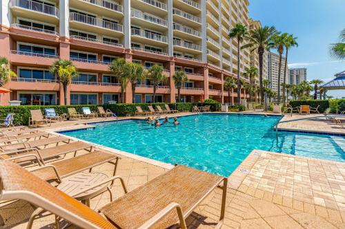 a swimming pool with chairs and a building at The Beach Club Resort and Spa II in Gulf Shores