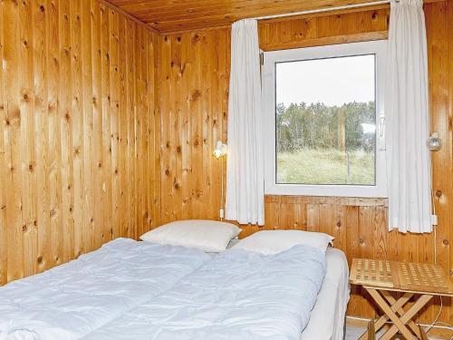 Torsted的住宿－Holiday home Thisted XL，木制客房的一张床位,设有窗户