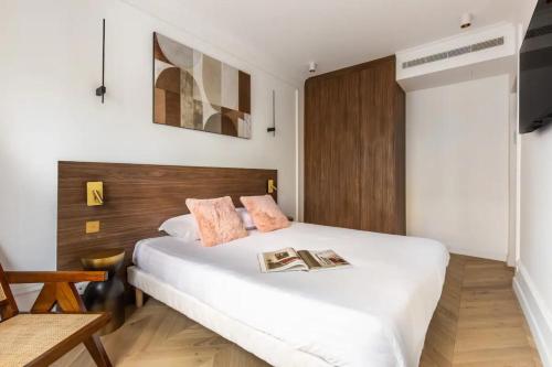 - une chambre avec un lit blanc et 2 livres dans l'établissement Luxurious & Central 2BD Apart for 4, à Paris