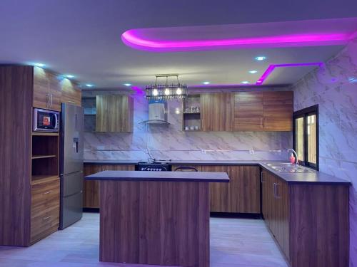 eine Küche mit einer Insel mit lila Beleuchtung in der Unterkunft Villa OMARI Situé à Saly Portudal Villa 2 Chambres bien équipés proche de tout in Saly Portudal