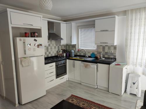 a kitchen with white cabinets and a refrigerator at Elif home in Kas