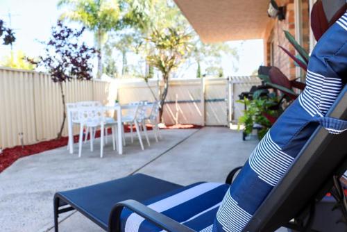 a patio with chairs and a table and a fence at Kennedy Drive Boutique Motel - Close To City Centre & Airport in Tweed Heads