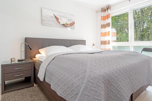 um quarto com uma cama grande e uma janela em Strandvilla Augustusbad Ostseeparadies em Scharbeutz