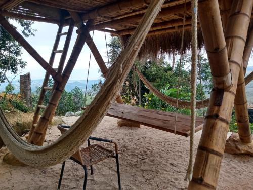 a hammock hanging from a hut on a beach at Casa Ecológica Madre Tierra in Curití