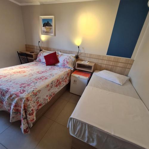a bedroom with two beds and two tables at Tulipa Hotel in Torres