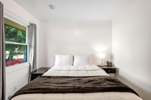 a white bedroom with a bed and a window at Cute as a Clam Cottage Room 5 in Ocean Park