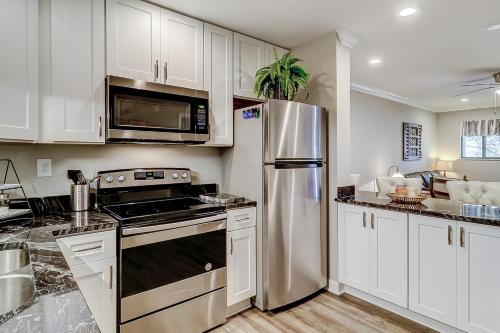 a kitchen with white cabinets and a stainless steel refrigerator at Spa on Port Royal Sound 1221 in Hilton Head Island