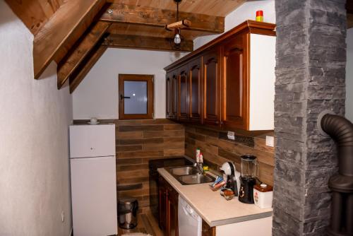 uma pequena cozinha com um lavatório e um frigorífico em Highlander guesthouse em Žabljak