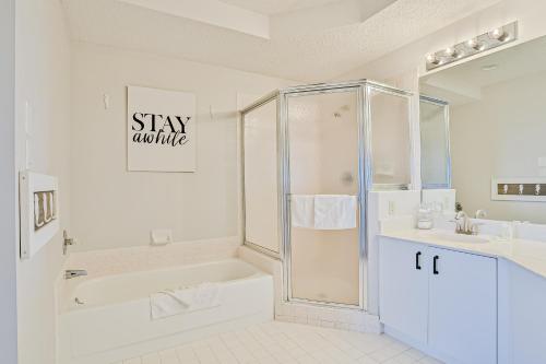 un bagno con doccia, vasca e lavandino di Ocean view condo with pool access, WiFi, & central AC - snowbirds OK a Marineland