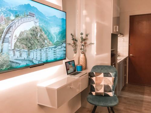 een tv aan een muur in een kamer met een stoel bij AZRA Bacolod at Mesavirre Garden Residences in Bacolod