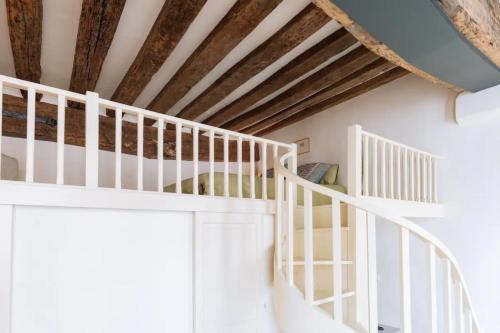 - un escalier blanc dans une chambre dotée d'un plafond en bois dans l'établissement Centrally located duplex Notre Dame, à Paris
