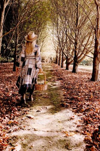 a woman in a hat walking down a path with a basket at Gleneagle Tasmania in Riana