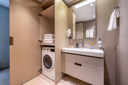 a bathroom with a sink and a washing machine at Casamax Suites in Antalya
