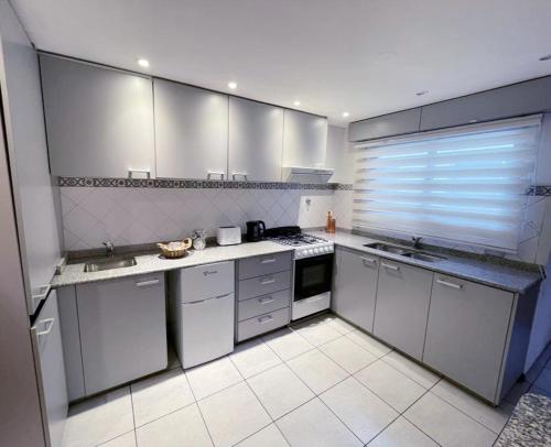 a kitchen with white appliances and a large window at Mendoza Your Apart in Mendoza