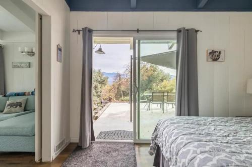 a bedroom with a bed and a sliding glass door at Black Bear Suite Hot Tub Sleeps 4 affordable in Oakhurst