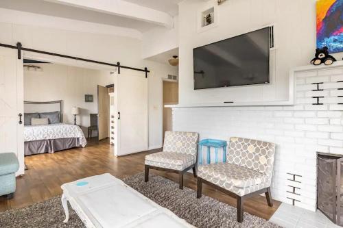 a living room with a fireplace and a tv on a wall at Black Bear Suite Hot Tub Sleeps 4 affordable in Oakhurst