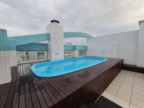 uma piscina num deque com um edifício em Apartamento pé na areia e piscina em Capão da Canoa
