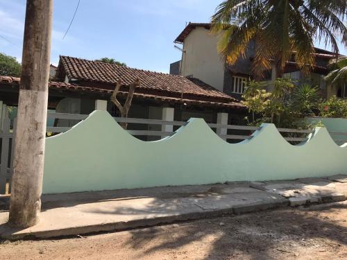 una cerca blanca frente a una casa en CASA GRIEBELER 02, en Cabo Frío