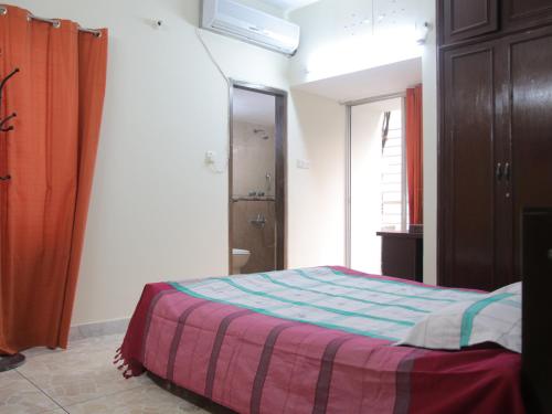 1 dormitorio con 1 cama con manta a rayas en Golpata Bed & Breakfast, en Dhaka