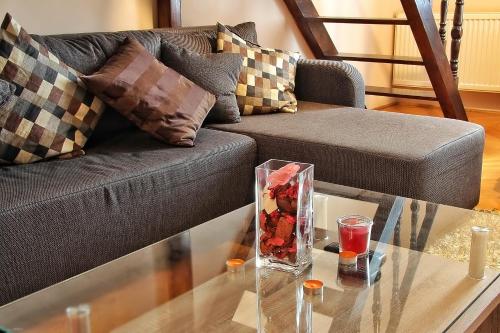 ブダペストにあるVaci Deluxe Apartmentのガラス張りのテーブル(ソファの上に花瓶付)