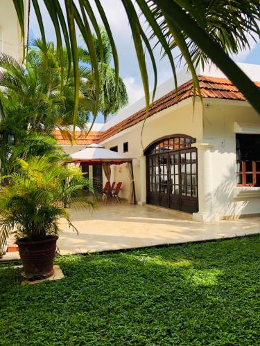 a house with a palm tree in front of it at Hotel Boutique Villas Segovia Cozumel in Cozumel