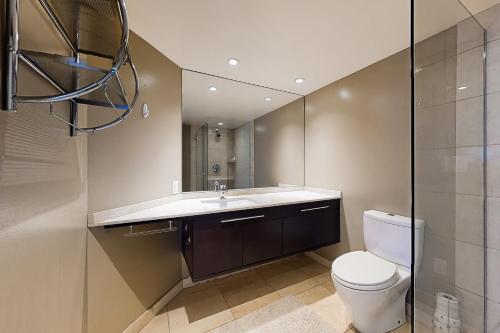 a bathroom with a toilet and a sink and a mirror at Next to the Market at Newmark in Seattle