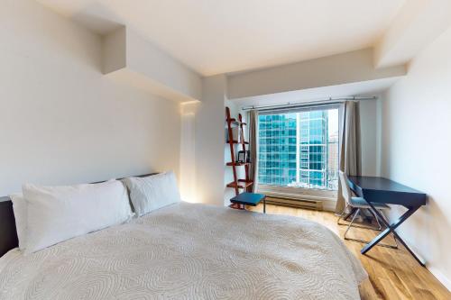 a bedroom with a bed and a desk and a window at Next to the Market at Newmark in Seattle