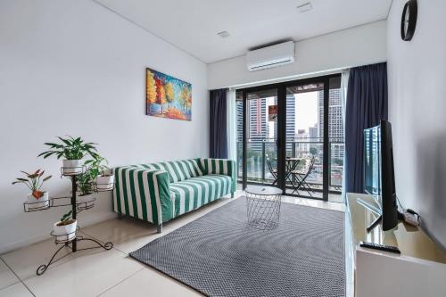 吉隆坡的住宿－Summer Suites KLCC Apartments by soulasia，带沙发和电视的客厅