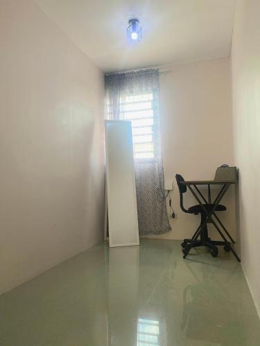 an empty room with a desk and a table and a window at 2 Bedroom townhouse in Bacolod City in Bacolod