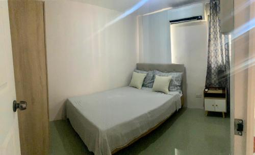 een kleine slaapkamer met een bed en een raam bij 2 Bedroom townhouse in Bacolod City in Bacolod
