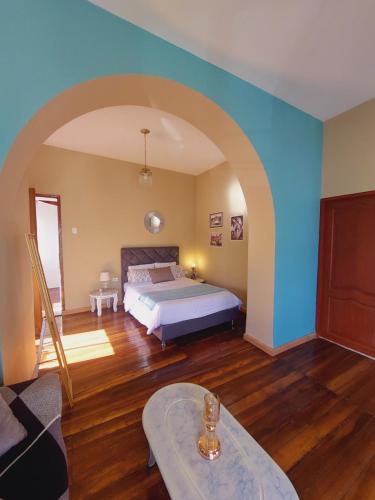 - une chambre avec un lit et un mur bleu dans l'établissement LACASADELCORONEL, à Quito