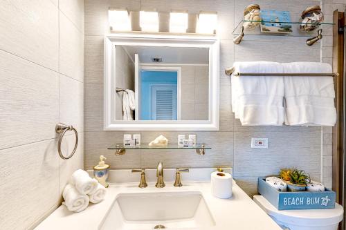 a bathroom with a sink and a mirror and towels at Turtle Time Suite in Satellite Beach