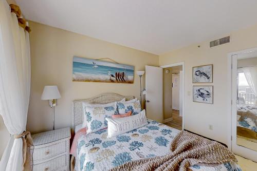 een slaapkamer met een bed met een blauwe en witte sprei bij The Beach House at Palace Resort 1911 in Myrtle Beach