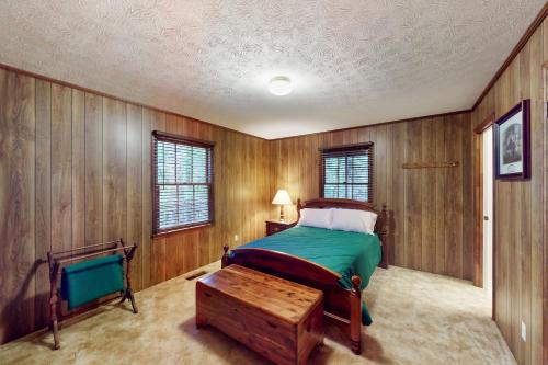 sypialnia z łóżkiem i drewnianą ścianą w obiekcie Low Cotton's Quarter w mieście West Point