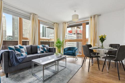 a living room with a couch and a table with chairs at Cubo Canary Wharf in London