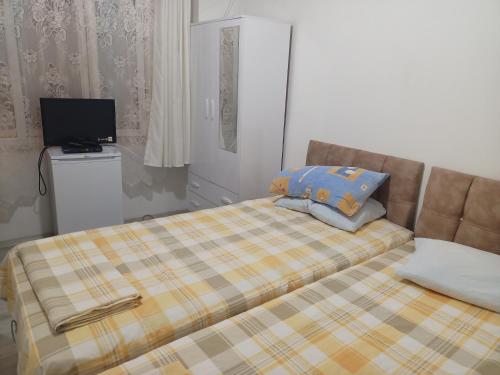 a bedroom with a bed and a television in it at Avcı Pansiyon in Gokceada Town