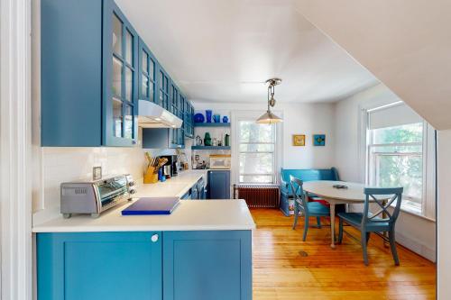 a kitchen with blue cabinets and a table with chairs at The Bean House Upstairs and Downstairs Unit in Camden