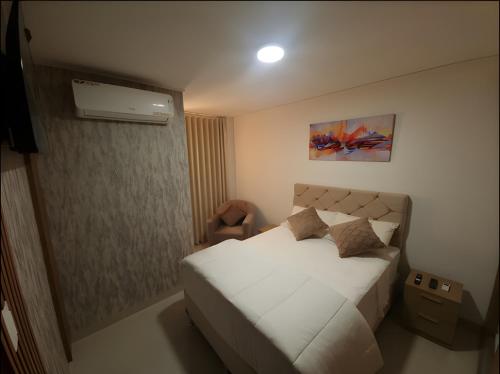 1 dormitorio con 1 cama blanca y aire acondicionado en Lujoso depto. en Equipetrol, en Santa Cruz de la Sierra
