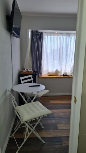 um quarto com uma mesa, uma cadeira e uma janela em B&B Rocas Santo Domingo em Santo Domingo