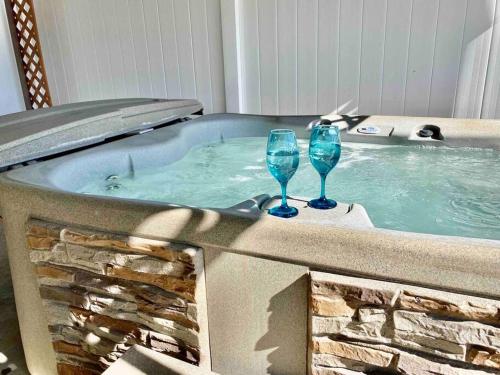 dos copas de vino sentadas en una bañera de hidromasaje en Crane Suite Hot Tub Bbq King Bed- Sleeps 4, en Ahwahnee