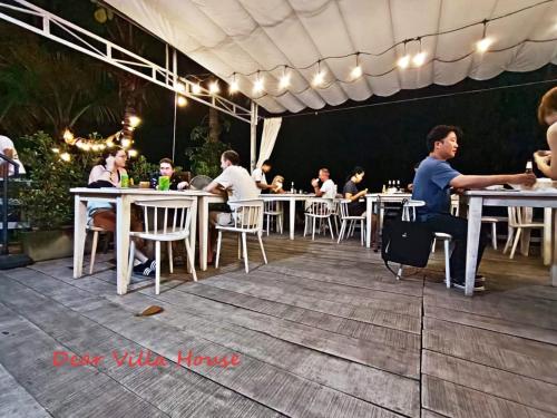 un grupo de personas sentadas en mesas en un restaurante en Dear Villa House en Luang Prabang