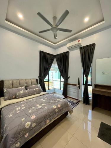 a bedroom with a bed and a ceiling fan at Tambun Hillview Cottage 2 in Ipoh