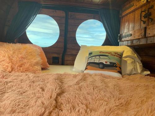 Bett in einem Zimmer mit zwei Kissen darauf in der Unterkunft Camper Van Hawaii in Kaneohe