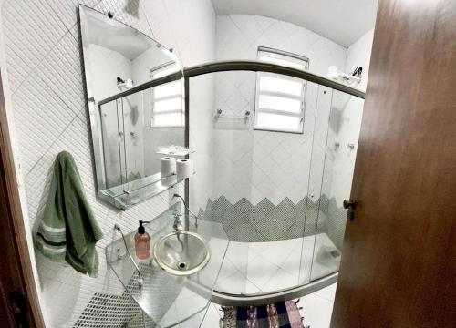 uma casa de banho com um lavatório e uma cabina de duche em vidro. em Rio Way Beach no Rio de Janeiro