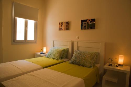 カマリにあるSea view housesのランプ2つと窓が備わるドミトリールームのベッド2台分です。