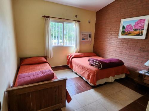 - une chambre avec 2 lits et une fenêtre dans l'établissement El Desafío, à Santa Ana