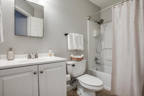 Baño blanco con aseo y lavamanos en Super Fun House in Perfect Location en San Antonio